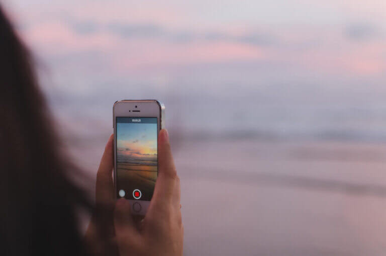 Girl taking a photo of sea